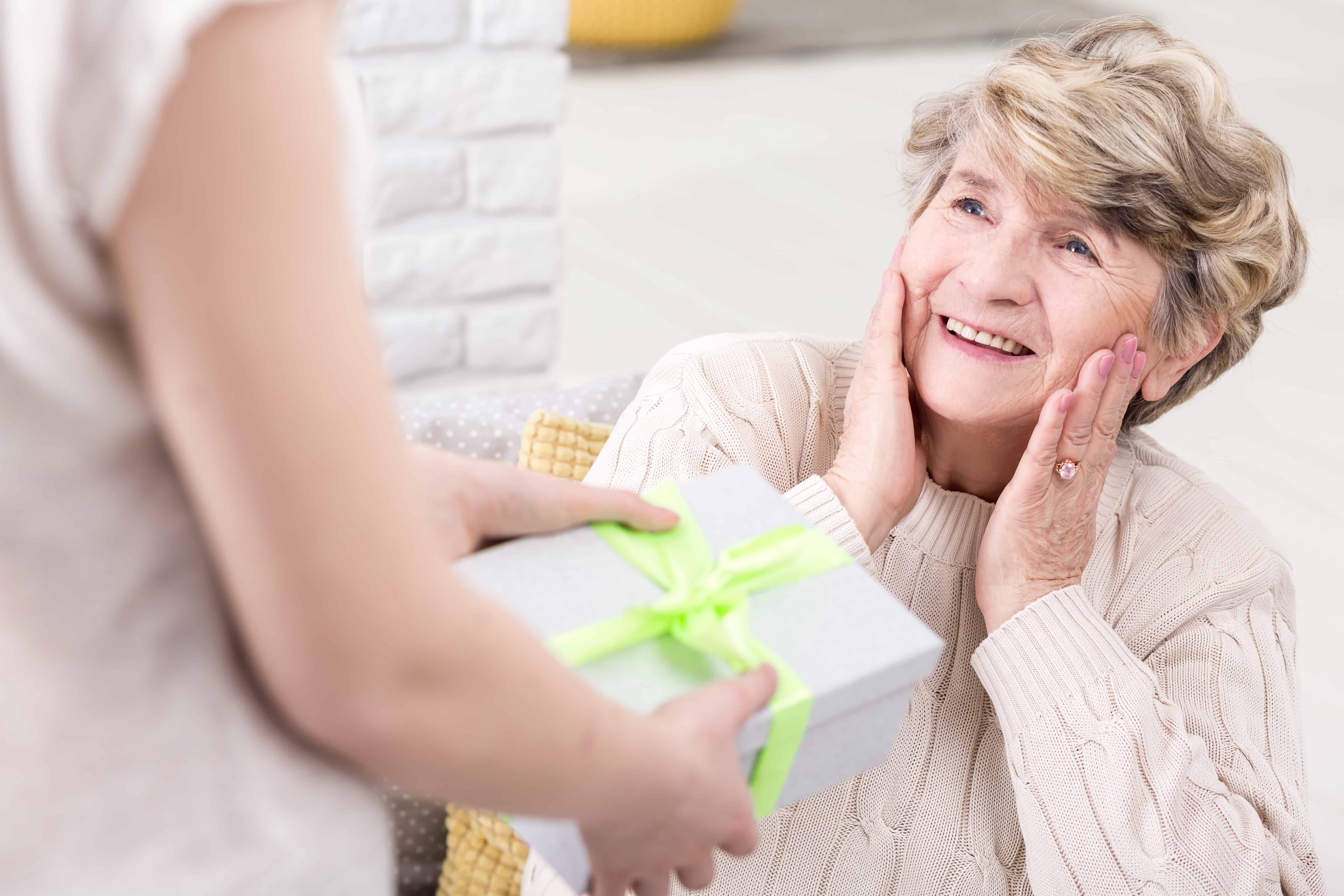 young woman giving a present to her surprised grandmother