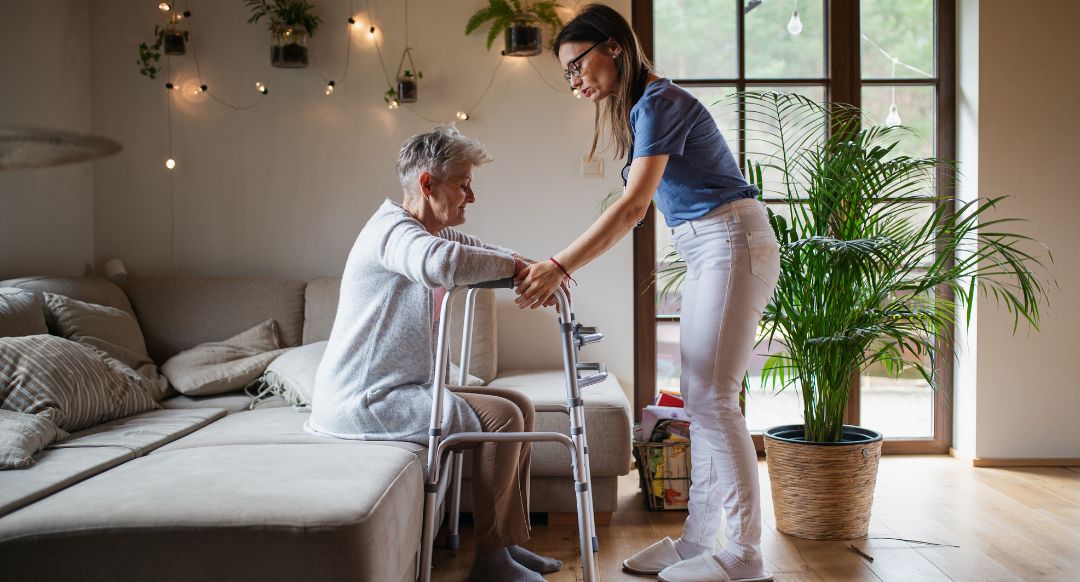 nursing home worker helping elderly woman with walker
