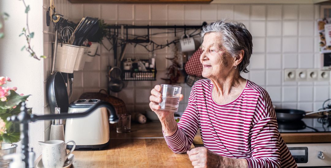 elderly woman sitting in kitchen