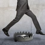 businessman jumping over bear trap