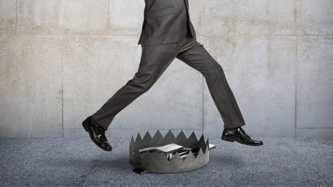 businessman jumping over bear trap